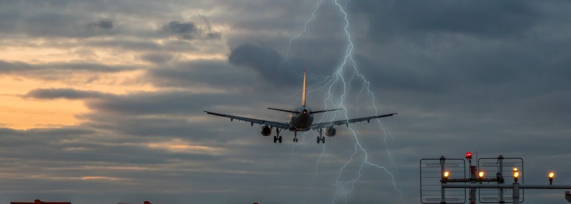 Flugzeug startet über Rollbahn mit Blitz im Hintergrund