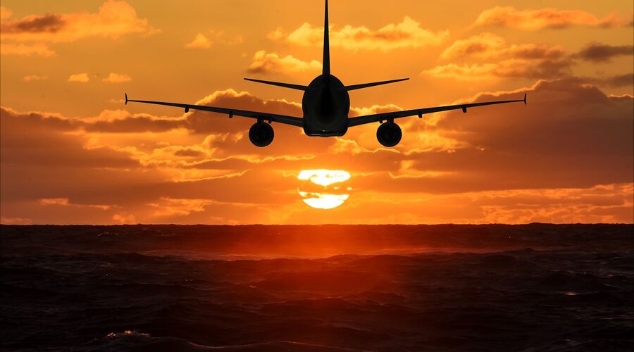Flugzeug fliegt gen Sonnenuntergang