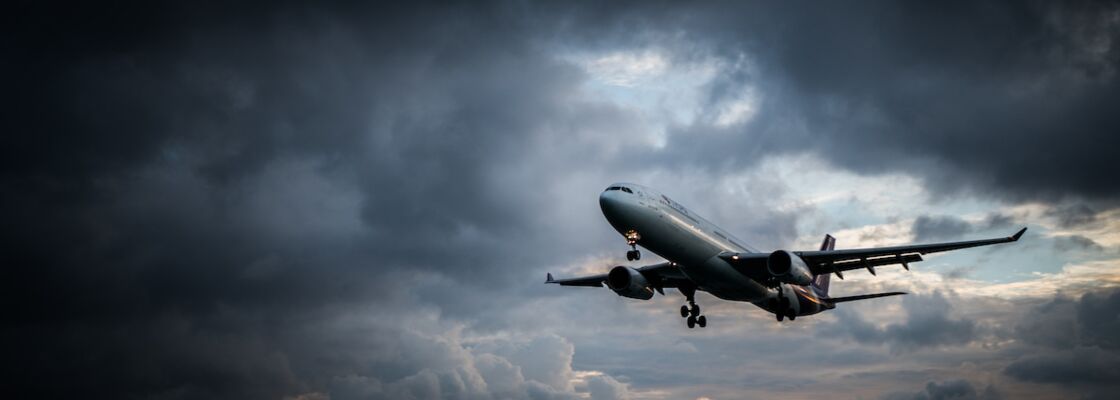 Flugzeug steigt in dunkle Wolken auf