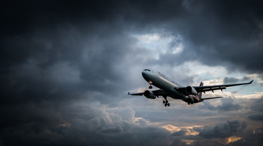 Flugzeug steigt in dunkle Wolken auf