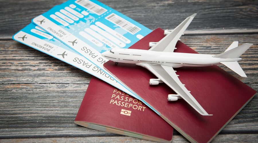 Flugtickets mit Reisepässen und Spielzeugflugzeug