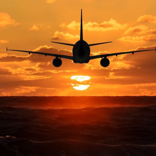 Flugzeug fliegt gen Sonnenuntergang