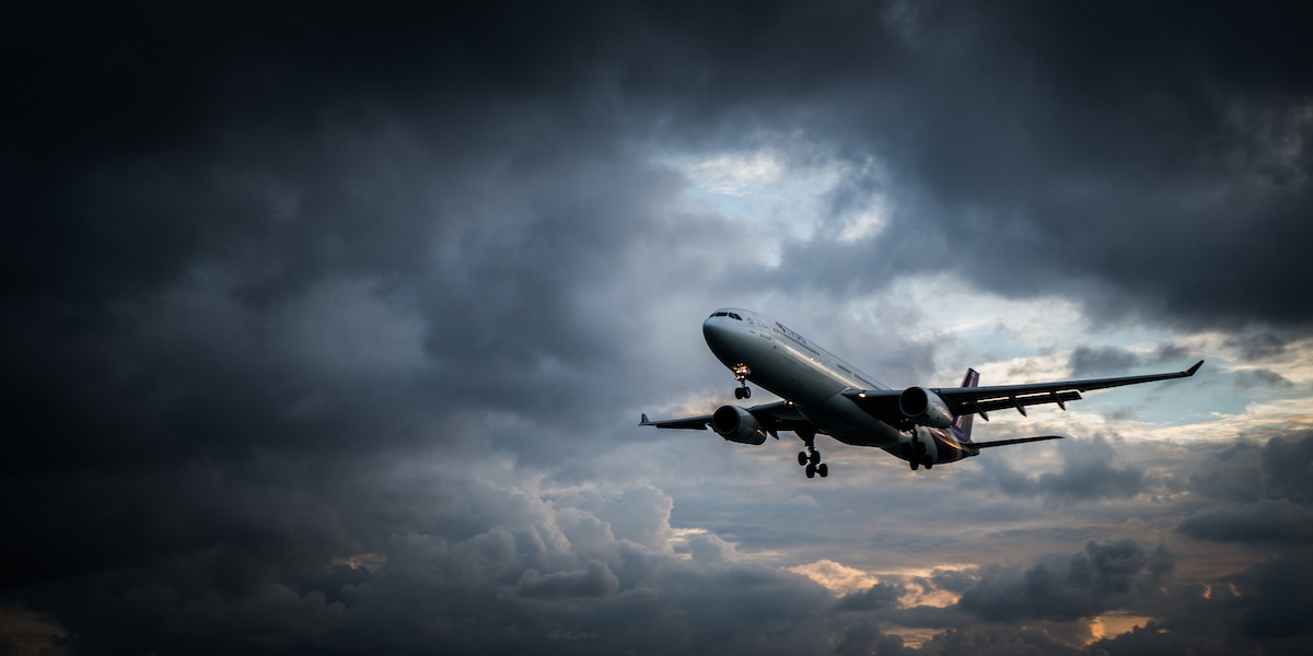 Flugzeug steigt in dunkle Wolken auf